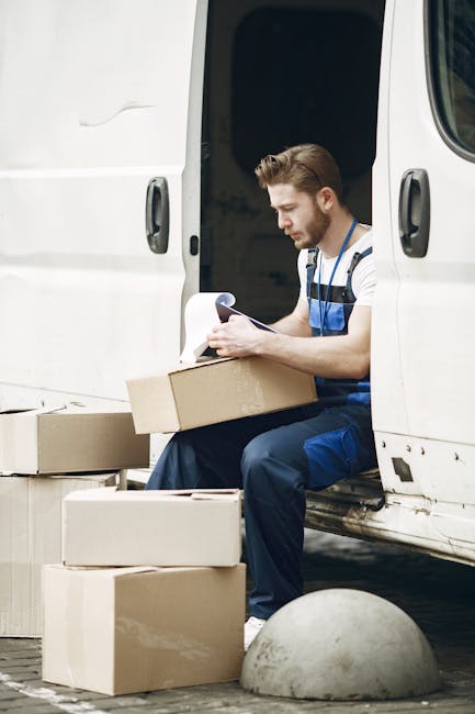 A collection of flattened cardboard boxes, some with handles and cutouts, stacked on top of each other on a floor, with one prominent box displaying the word 'DEADLINE' in bold black letters. The boxe